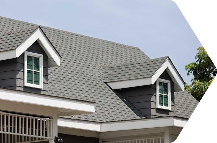 The grey asphalt shingle roof of a 1.5 story home featuring two front dormers in Austin Texas