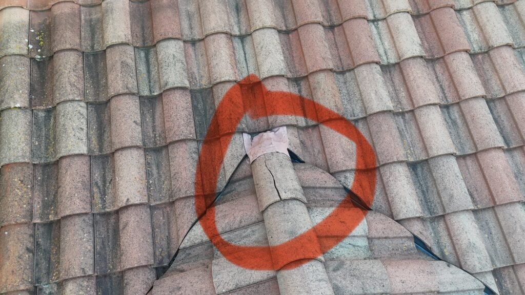 Hip shingles of a concrete tile roof showing a crack that can let water into the roof below.