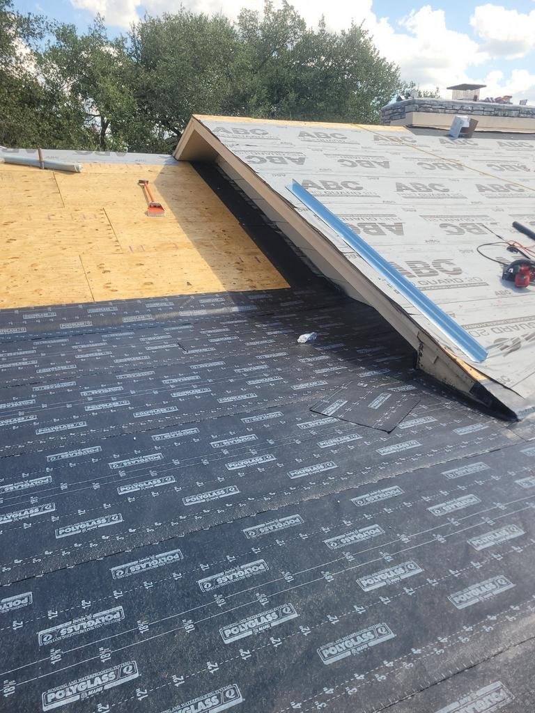 Underlayment being installed on a roof deck by Impact Resistant Roofing.